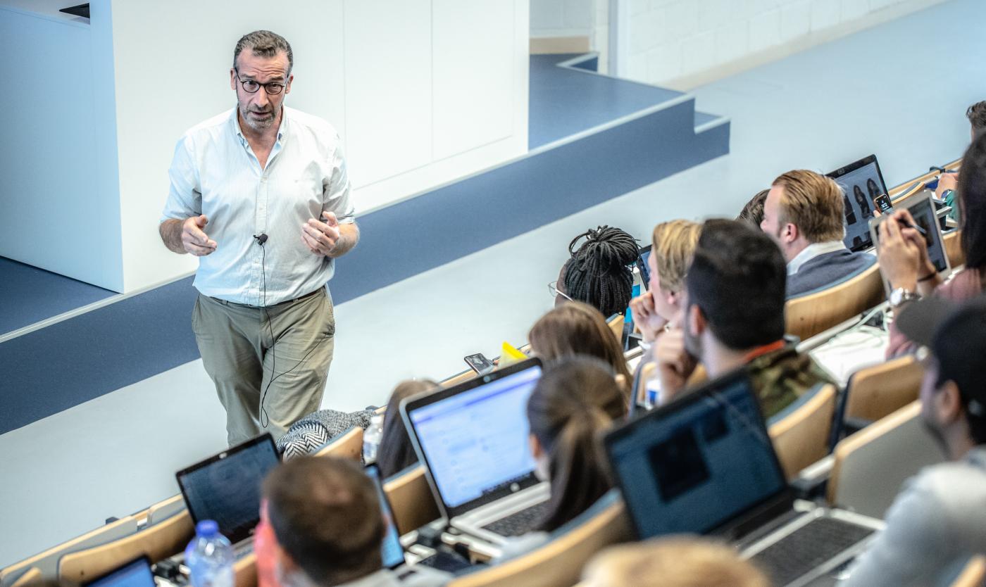 Professo aan het praten tegen studenten tijdens les in een aula van het Gebouw I op Campus Etterbeek