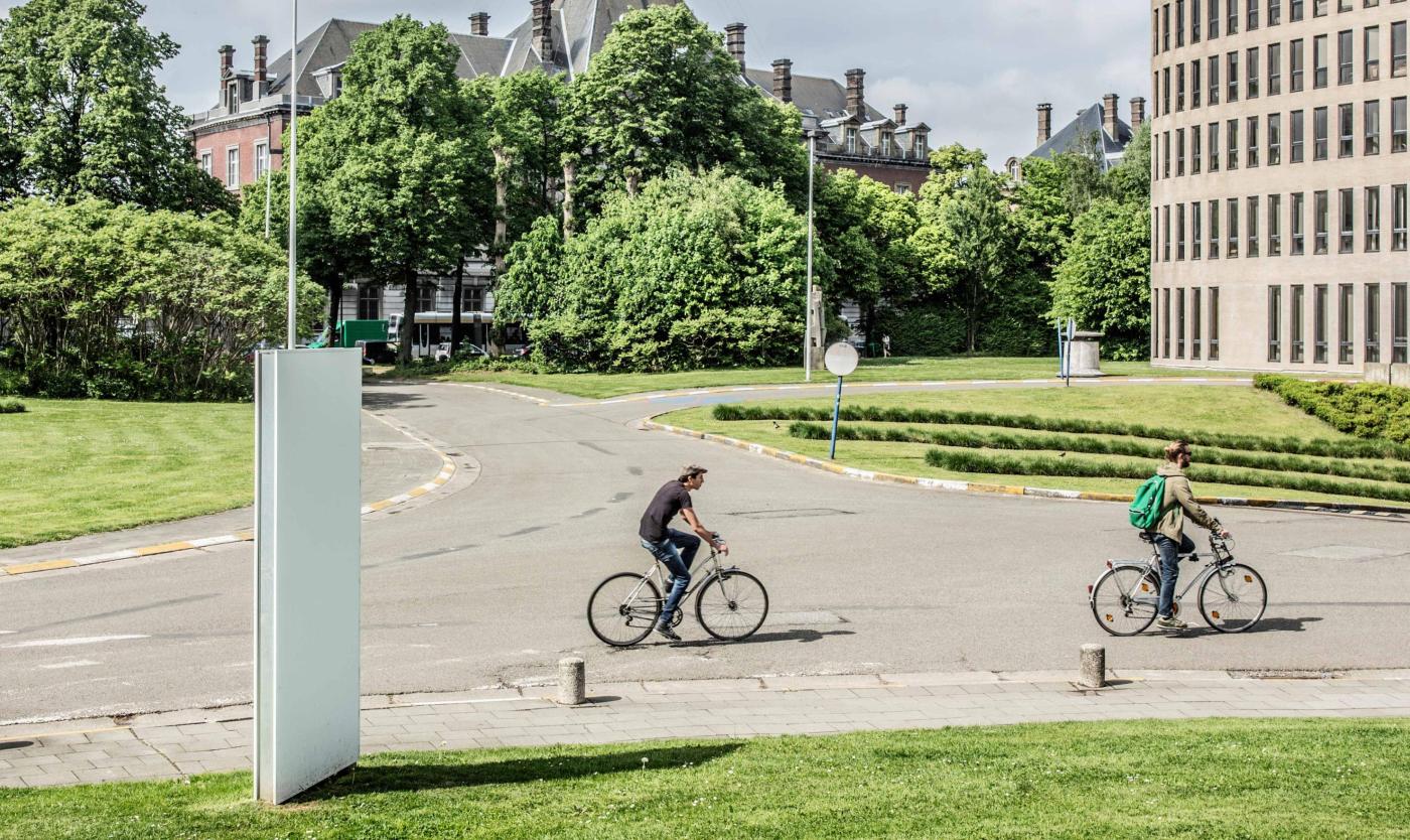 2022_Living Campus Walk_Koning fiets_Twee mannen op de fiets aan het Braemgebouw_Etterbeek_VUB
