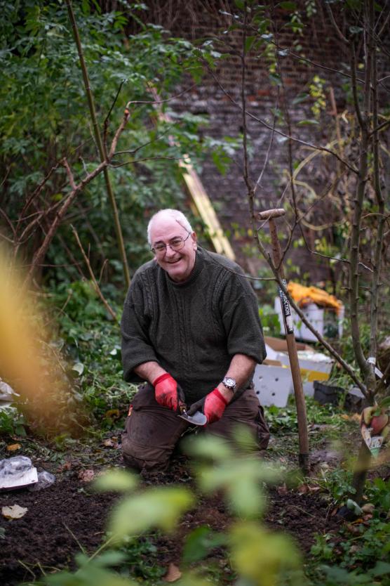 Docent Alex Liesenborghs wroetend in de tuin