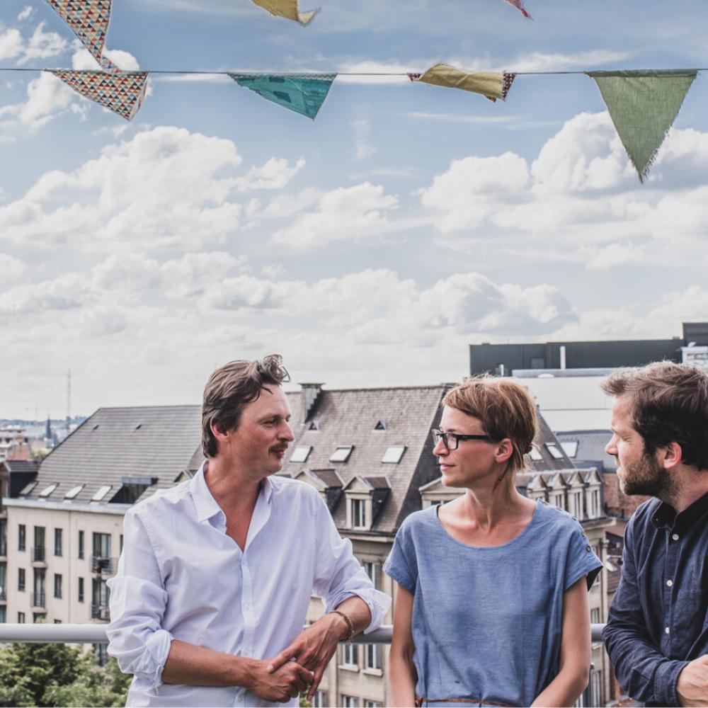 Vrouw en twee mannen in conversatie op een event