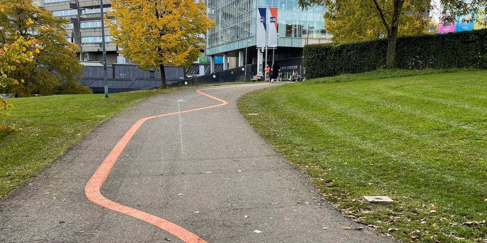 Oranje streep op het pad naar de Esplanade op Campus Etterbeek